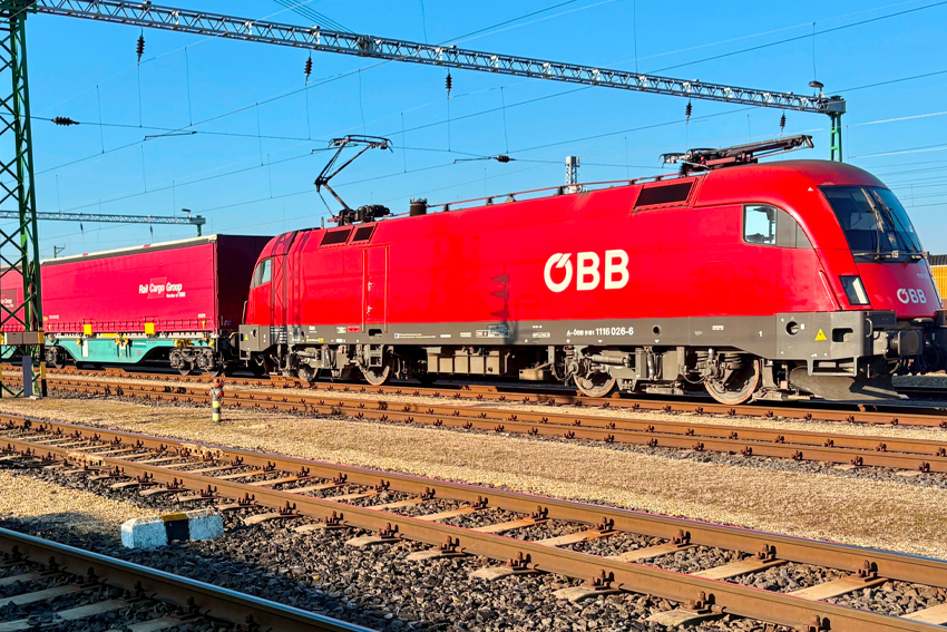 ÖBB-Lokomotive zieht Güterwagen der Rail Cargo Group auf einer Bahnstrecke