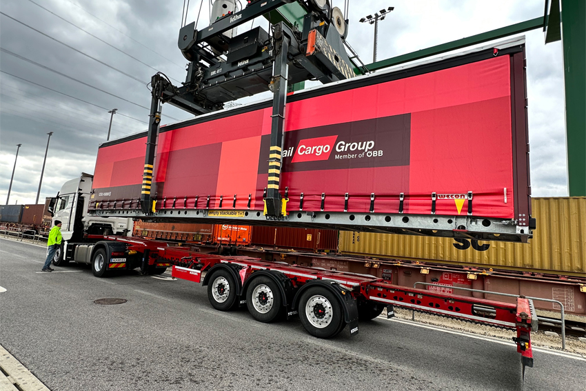 Umschlag eines Rail Cargo Group Wechselaufbaus zwischen Straße und Schiene in einem multimodalen Terminal.